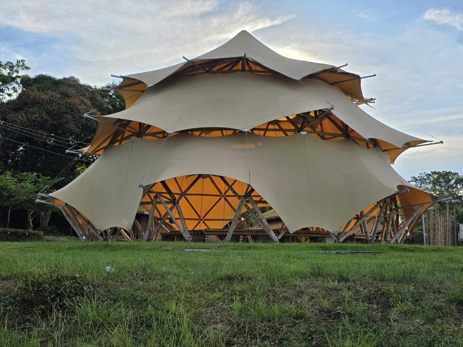 Interior of the Banwag dome glowing at dusk, bamboo lattice visible